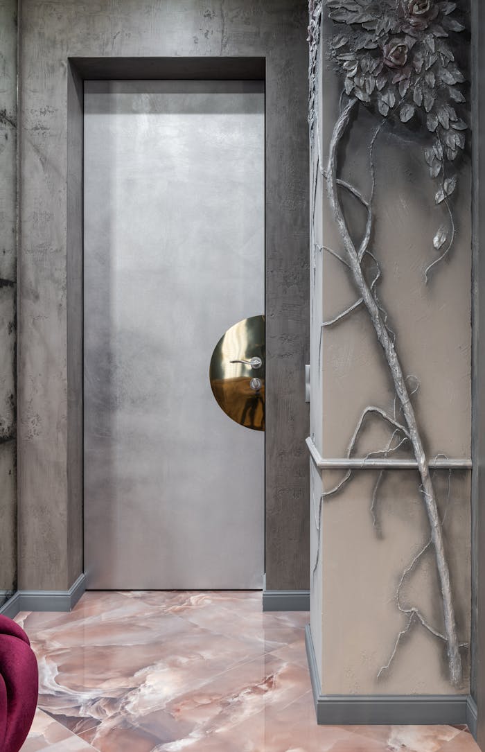 Stylish modern interior with a sleek metal door and artistic wall embellishments.
