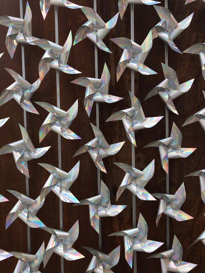 Close-up image of a wall art display featuring reflective pinwheels arranged in an intricate pattern.